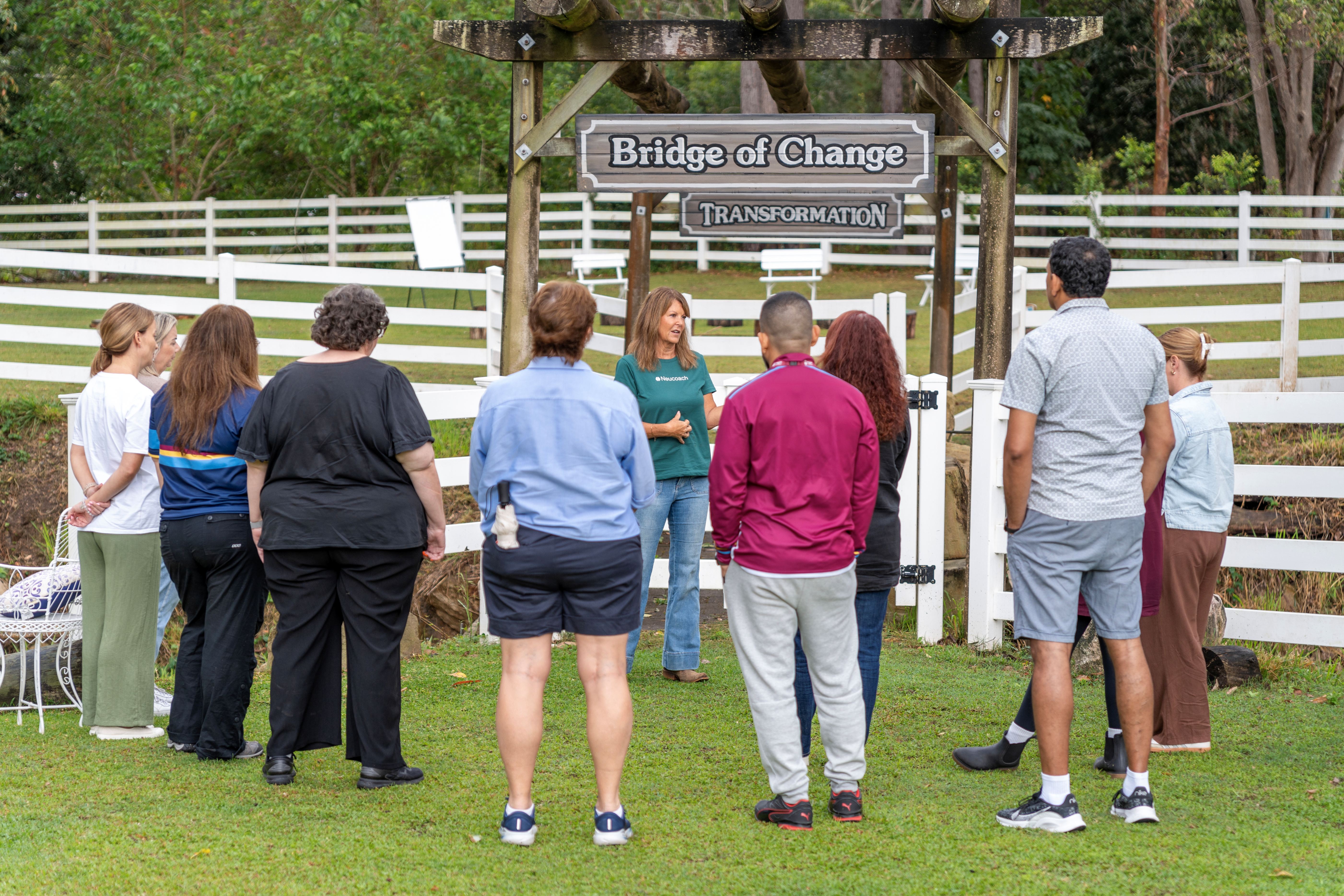 A white gate opening onto a jacaranda-lined pathway into the Gold Coast hinterland, an invitation to step into a different way of leading.
